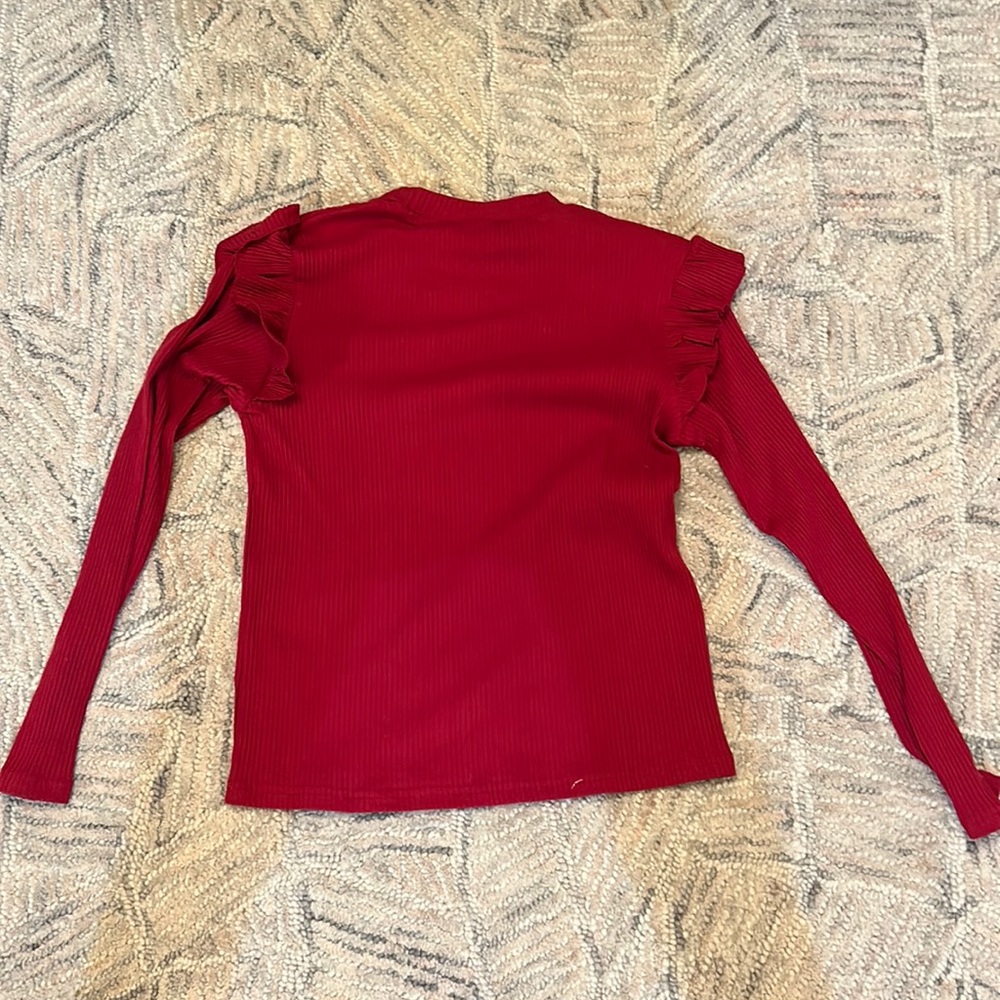 She in red top with ruffles on sleeves